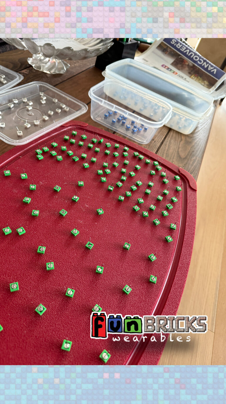 Handmade LEGO brick earrings laid out to dry on a red tray.