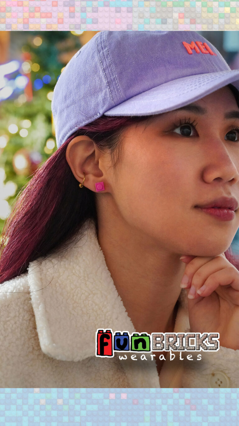 Woman in a purple cap and sherpa jacket wearing pink LEGO earrings.