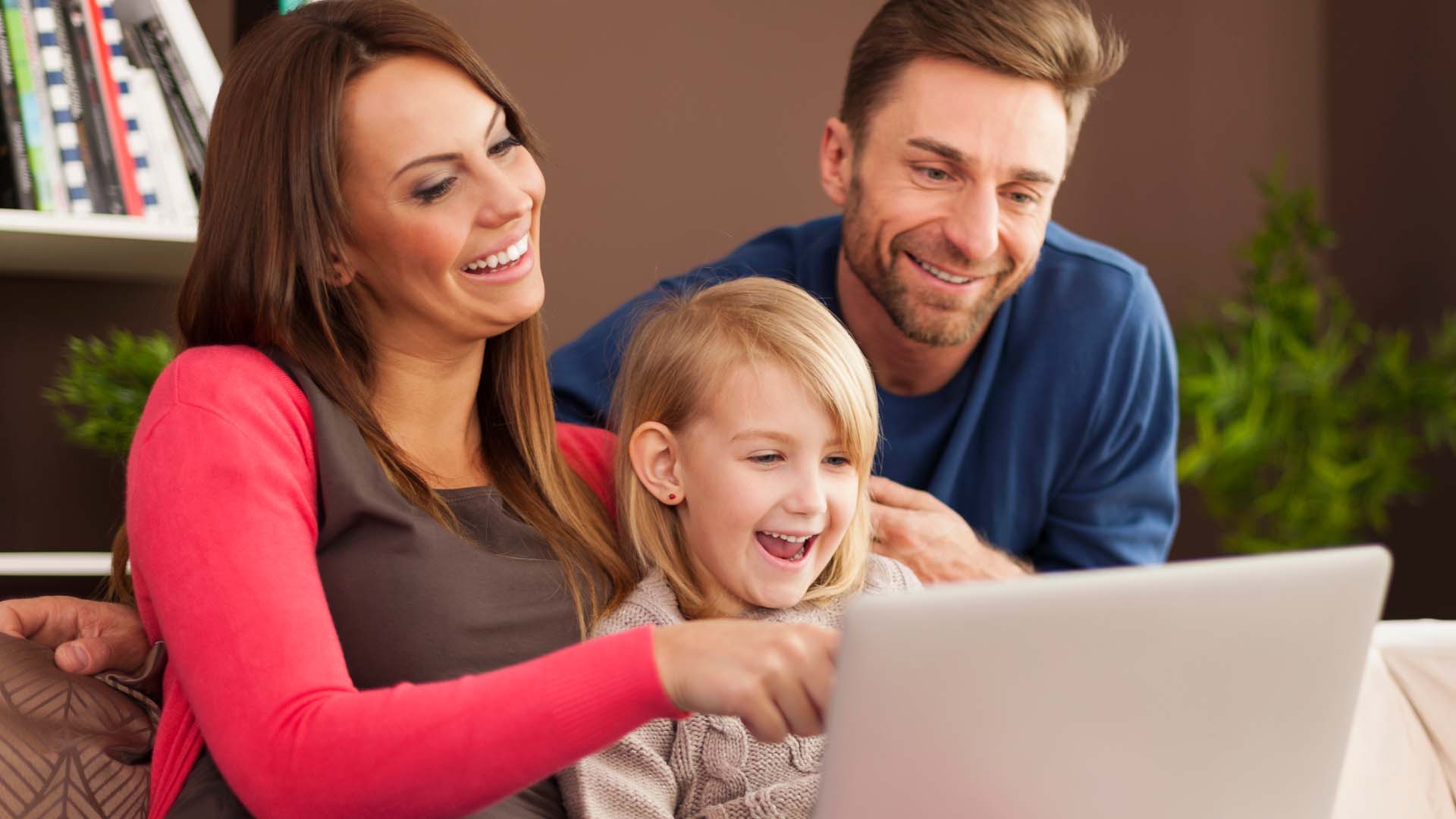 Parents and child browsing a dance studio website on a laptop at home