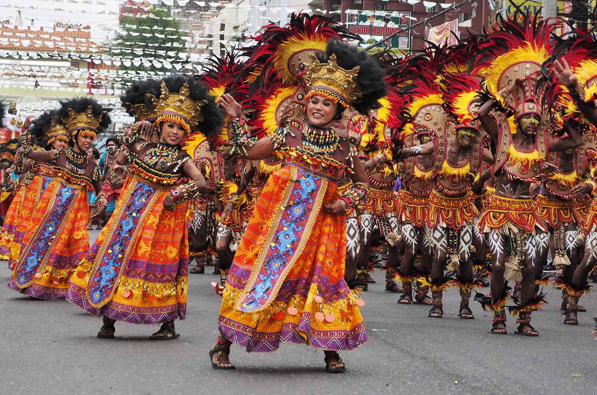 Filipino Festival Dance and Asian Heritage in Movement | Marketing Movez Traditional Filipino festival dancers performing in colorful cultural costumes during a street parade celebration inspired by Indigenous and folk dance traditions.