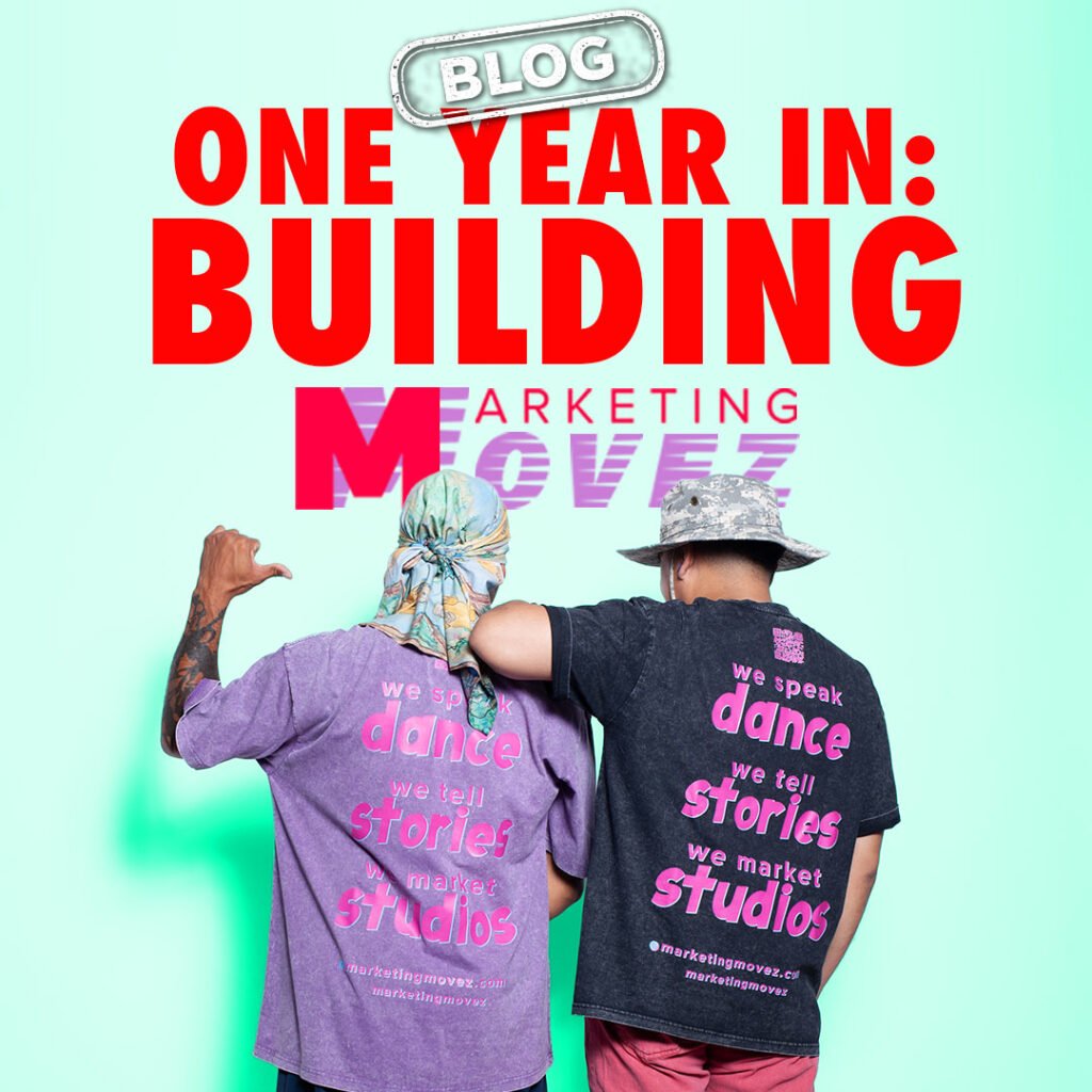One Year In Building Marketing Movez Blog Two dancers standing side by side in branded shirts with “One Year In Building Marketing Movez” blog title and a blog stamp above