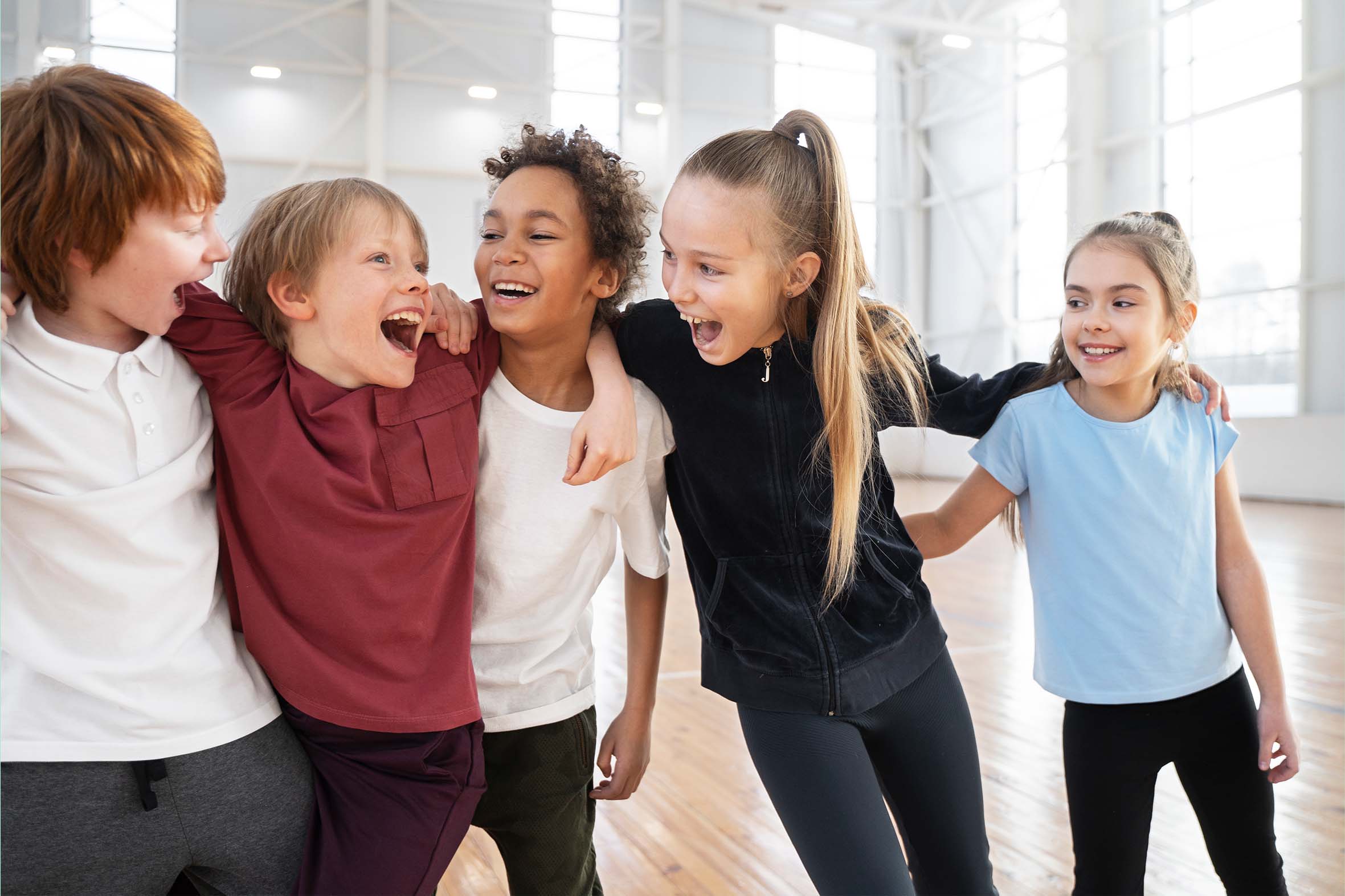 Strong Dance Communities Are Built Through Connection Group of diverse young dancers smiling and laughing together in a dance studio, representing friendship, inclusion, teamwork, and a positive studio culture.