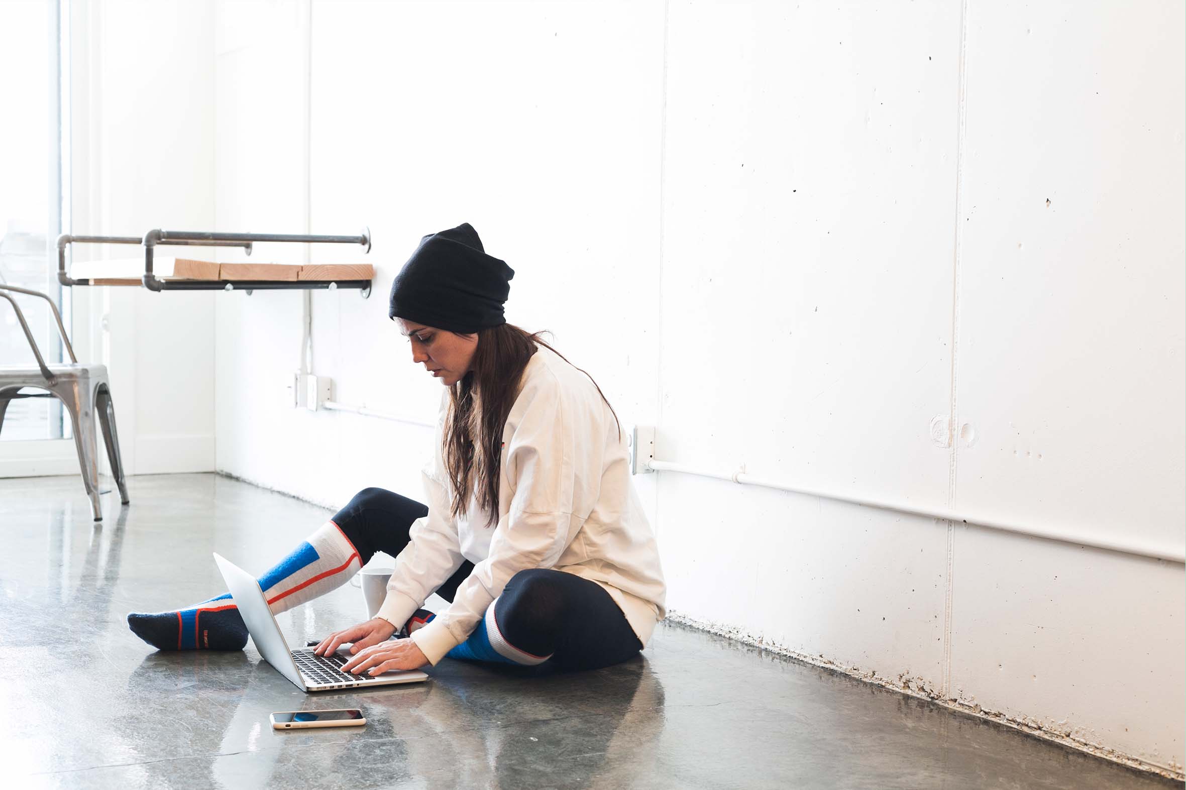 Where ChatGPT Fits into Dance Studio Marketing Dance professional sitting on a studio floor working on a laptop, representing the use of AI tools and content creation within dance studio marketing.