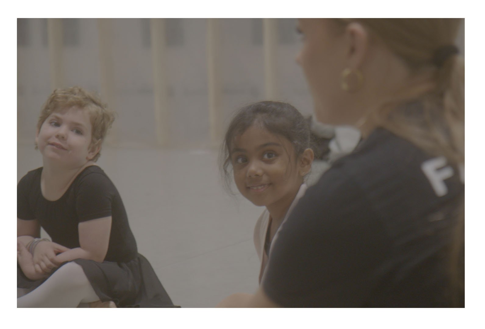 Young Dance Xpressions students sitting together during a studio class